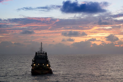 An anchor handling tug boat maneuvering during sunrise at offshore terengganu oil field