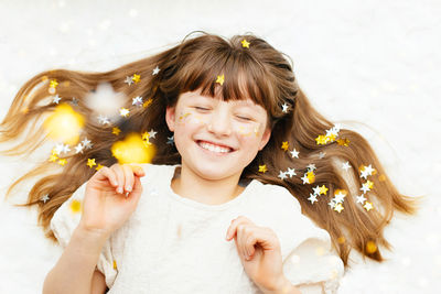 Portrait of a pretty girl with star-shaped sequins on her face. the girl smiles. fun holiday, party