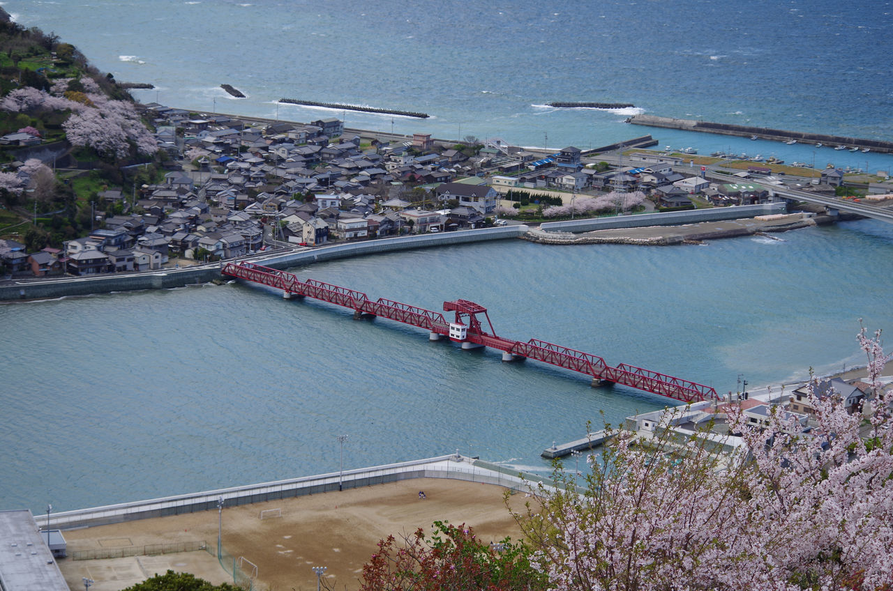 water, built structure, architecture, sea, building exterior, high angle view, city, transportation, cityscape, flying, river, nautical vessel, blue, travel, day, outdoors, town, aerial view, mode of transport, harbor