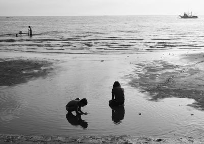 High angle view of silhouette children playing at beach against sky