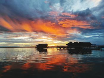 Scenic view of sea against dramatic sky during sunset