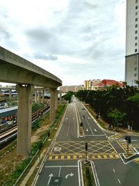 Road by bridge in city against sky