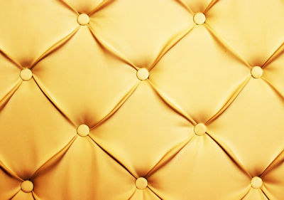 Full frame image of gold chesterfield sofa