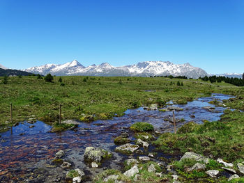 Scenic view of snowcapped mountains against clear blue sky