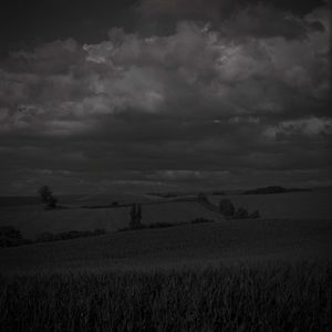 Scenic view of field against storm clouds