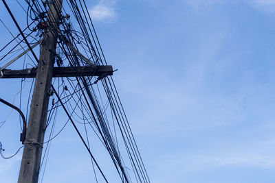 Close up old electricity poles with telephone lines many. under sky background.