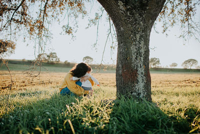 Side view of woman sitting on field