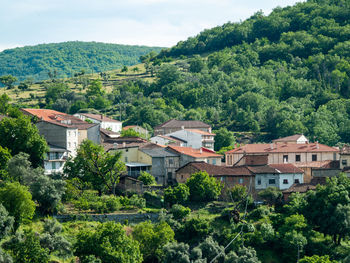 High angle view of houses by trees and mountains