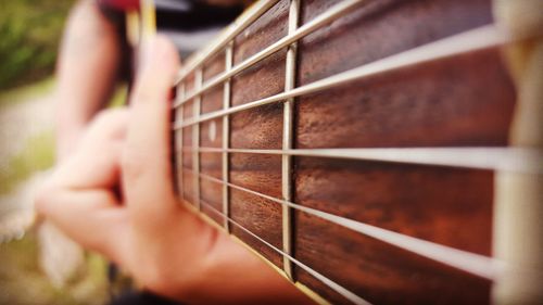 Cropped image of person playing guitar