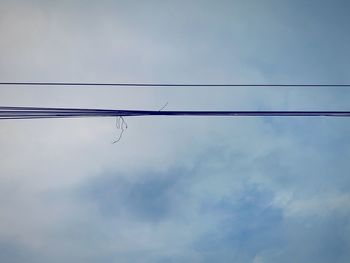 Low angle view of silhouette cables against sky