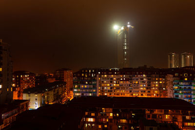 Illuminated buildings against sky at night