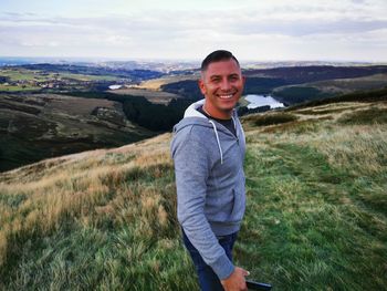 Portrait of smiling young man standing on landscape