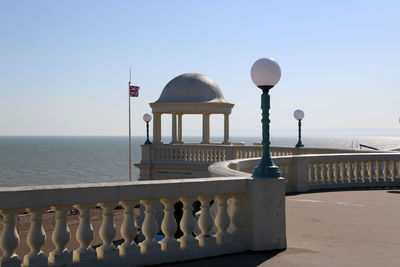 View of street light by sea against clear sky