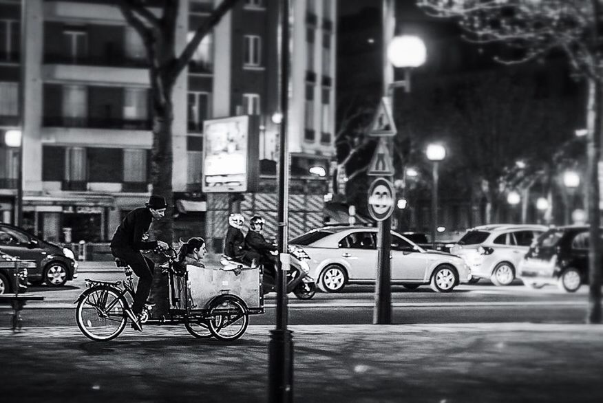 bicycle, land vehicle, transportation, mode of transport, street, city, parked, parking, building exterior, illuminated, stationary, built structure, night, city life, architecture, car, street light, city street, road