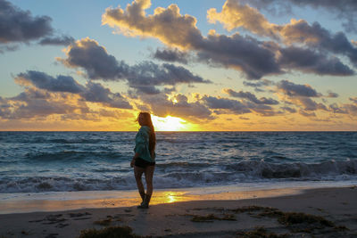 Full length of man standing on beach during sunset