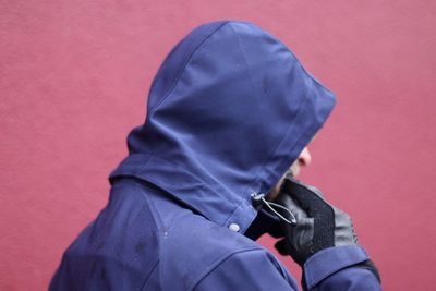 Midsection of person holding umbrella against wall