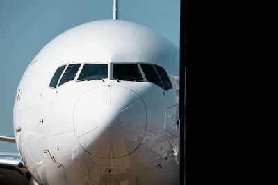 Close-up of airplane on runway against clear sky