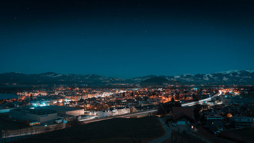 High angle view of illuminated cityscape against sky at night