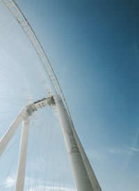 Low angle view of rollercoaster against clear blue sky