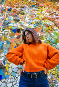 Beautiful young woman standing against the wall