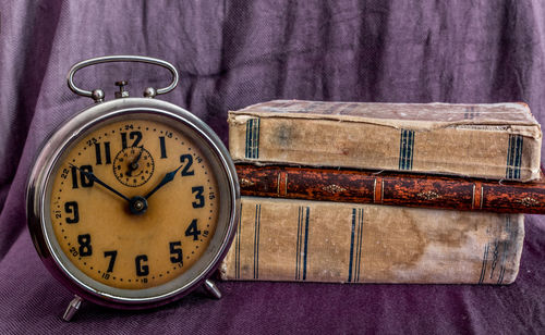 Close-up of alarm clock against books