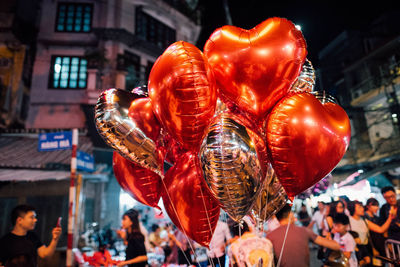 Close-up of heart shaped balloons in city at night