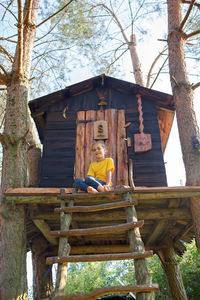 Rear view of woman sitting on roof