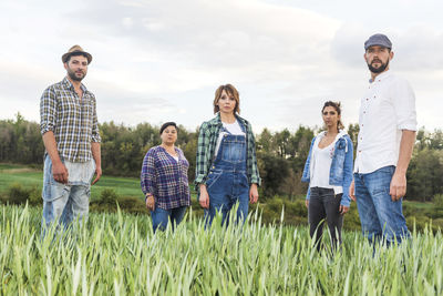 Portrait farmers standing on farm against sky during sunset