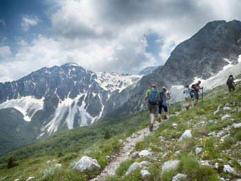 People on mountains against sky