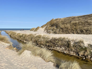 Scenic view of beach against clear blue sky