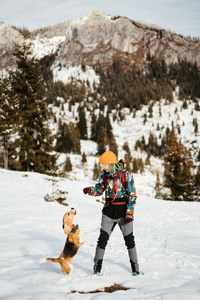 Rear view of man skiing on snow covered field