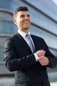 Happy young businessman looking away