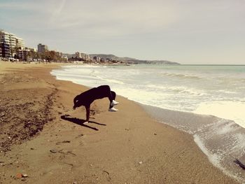 Man doing handstand at beach