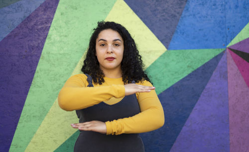 Portrait of woman standing against wall