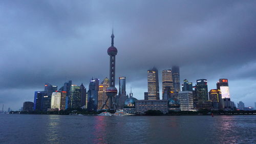 Modern buildings in city against cloudy sky