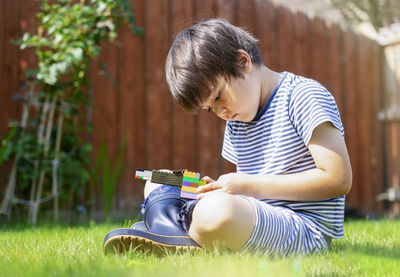 Low angle view of boy playing with toy blocks on land