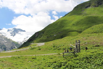 Scenic view of green landscape and mountains against sky