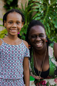 Portrait of smiling mother and daughter standing outdoors