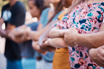 Midsection of people stacking hands