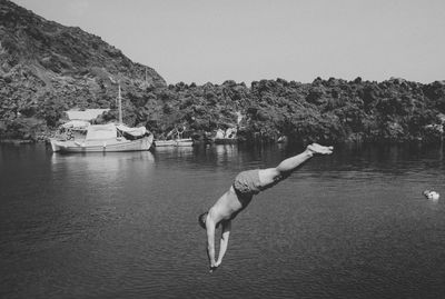 Shirtless man diving into sea