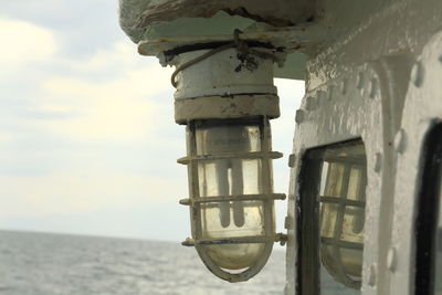Close-up of light bulb on boat against sky