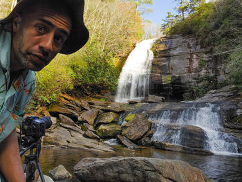 Young man looking at waterfall
