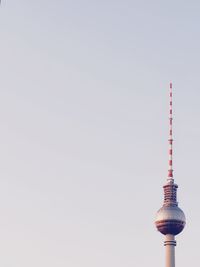 Low angle view of communications tower against sky in city