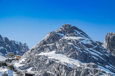 Scenic view of snowcapped mountains against clear blue sky