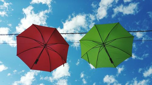 Colors umbrellas on the blue sky with white clouds background 