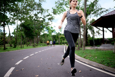 Full length of woman on road against trees