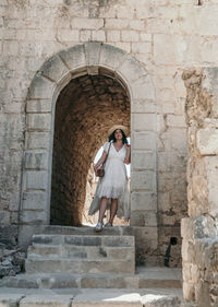 Portrait of woman exploring old medieval settlement inside a fortress of klis near split in croatia.