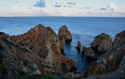 Scenic view of rocks in sea against sky