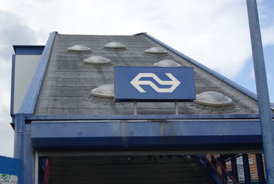 Low angle view of text on building against sky