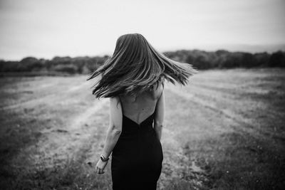 Rear view of woman standing on field